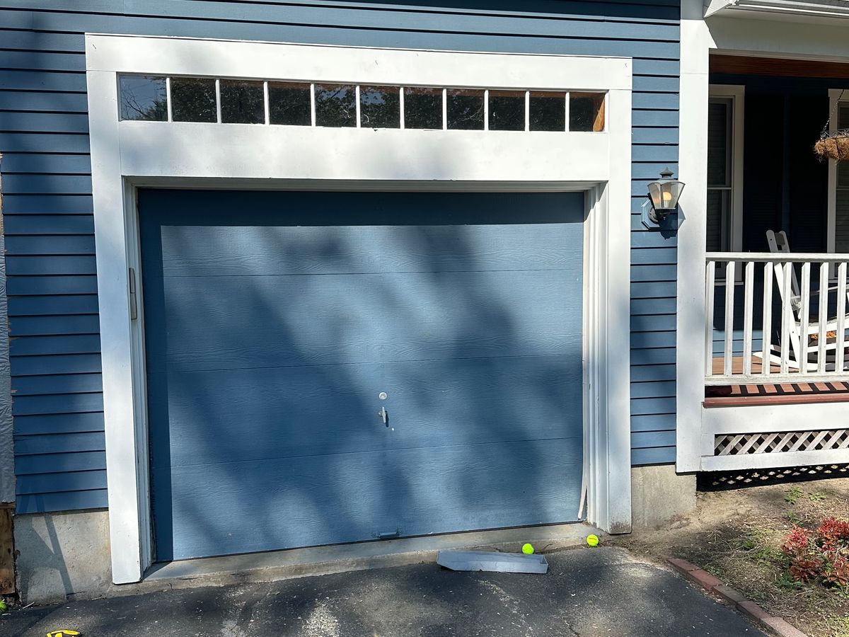 Slate blue modern garage door with side windows on colonial blue home